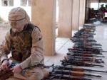  U.S. Army Pfc. Reed Roalf from Headquarters and Headquarters Company, 1st Battalion, 325th Airborne Infantry Regiment, labels AK-47 assault rifles captured during Operation Bulldog Mammoth 