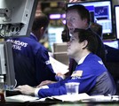 In this Nov. 4, 2010 photo, traders work on the floor to the New York Stock Exchange, in New York.