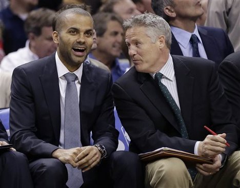 In this March 6, 2013, photo, San Antonio Spurs' Tony Parker, left, of France, sits with assistant coach Brett Brown during an NBA basketball game in San Antonio. The Philadelphia 76ers have reportedly offered Brown their long-vacant coaching job. Brown was in final discussions Friday night, Aug. 9, 2013, with Philadelphia regarding terms and finances, according to Yahoo! Sports. The Sixers have been searching for a coach since Doug Collins resigned in April. (AP Photo/Eric Gay)