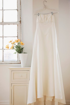 Wedding dress hanging in bed room