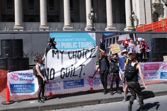 Pro_choice banner held in front of Pro-Life stage