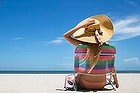 Woman relaxing in lawn chair on beach