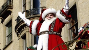 Santa Claus waves as he rides on his float down Central Park West during the 87th Macy's Thanksgiving Day Parade.