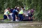 Police and survivors recover a jetboat that crashed, killing one and injuring four others. Photo / John Cowpland