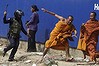 A security guard chases away Buddhist monks from a camp occupied by anti-government demonstrators in Phnom Penh January 4, 2014. Cambodian security guards and city workers, watched over by riot police, dismantled a camp occupied by anti-government demonstrators on Saturday, a day after a bloody crackdown on garment factory workers allied with the protest movement.  REUTERS/stringer (CAMBODIA - Tags: SOCIETY CIVIL UNREST RELIGION TPX IMAGES OF THE DAY)