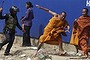 A security guard chases away Buddhist monks from a camp occupied by anti-government demonstrators in Phnom Penh. 