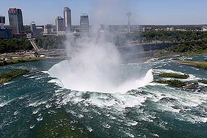 The town of Niagara Falls, Canada is seen past a cloud of mist rising over Horseshoe Falls, the largest of the Niagara Falls 