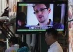 A TV screen shows the news of Edward Snowden, former CIA employee who leaked top-secret documents about sweeping U.S. surveillance programs, at a restaurant in Hong Kong Wednesday, June 12, 2013.