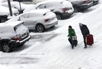 Travelers walk in the economic parking lot at O'Hare International Airport in Chicago on Sunday, Jan. 5, 2014.