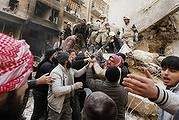 Free Syrian army members remove a body from rubbles from damage caused by what activists said was an airstrike.