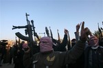 Gunmen gather in a street as they chant slogans against Iraq's Shiite-led government and demanding that the Iraqi army not try to enter the city in Fallujah, 40 miles (65 kilometers) west of Baghdad, Iraq, Tuesday, Jan. 7, 2014.