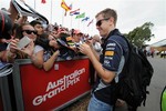 Red Bull driver Sebastian Vettel of Germany signs his autographs ahead of the first practice session for the Australian Formula One Grand Prix at Albert Park in Melbourne, Australia