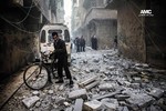 File - In this Monday, Dec. 23, 2013 citizen journalism image provided by Aleppo Media Center AMC, which has been authenticated based on its contents and other AP reporting, Syrians inspect damages buildings following a Syrian government airstrike in Aleppo, Syria.