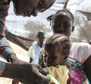 A staff member from the International Medical Corps provides health services to a young displaced child currently taking refuge on UN grounds in Juba, South Sudan, 6 January, 2014.