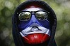 An anti-government protester wears a mask in national colours in Thailand