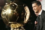 Portuguese international soccer star Cristiano Ronaldo watches his 'Ballon d'Or' (Golden Ball) award, during a photocall at the studios of a French television channel, following a live brodcast soccer show, Sunday, Dec. 7, 2008 in Paris.