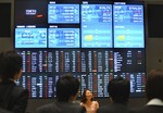 Freshmen listen to an explanation in front of an electric market board during their training at Tokyo Stock Exchange in Tokyo, Thursday, Apr. 9, 2009. The benchmark Nikkei 225 stock average increased 1.84 percent to 8,753.39 at the end of the morning session