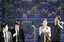 People wait to cross a street in front of the electronic stock board of a securities firm in Tokyo, Japan, Monday, April 2, 2012.