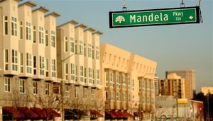 A sign for Mandela Parkway hangs in front of the Mandela Gateway apartment complex, left, in Oakland, Calif., on Thursday, Dec. 12, 2013. The name of former South African president Nelson Mandela can be seen on hundreds of streets, buildings and other community facilities, from Africa to Asia and Europe to the Americas.