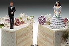 Bride and groom figurines standing on two separated slices of wedding cake