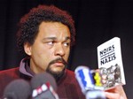 FILE - In this Feb. 19, 2005 file photo, French comic Dieudonne M'Bala M'Bala looks at a book "Blacks in the Nazi camps" by Serge Bile during a statement at La Main d'Or theater, in Paris. The Paris prosecutor's office said Thursday Jan 2, 2013, it is investigating threats against a comedian the French interior minister wants banned from the stage for what he says are racist and anti-Semitic performances.