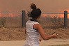 Residents run from a fast moving grass fire which gets close to homes in the Melbourne northern suburb Craigieburn, Feb. 9, 2014. A total fire ban is in plce across Victoria during the heat wave temperatures while several fires are burning throughout the state.(AAP Image/David Crosling) NO ARCHIVING