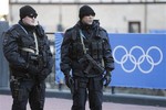 Russian security forces stand guard as the Olympic torch makes it's way through the streets of the Rosa Khutor ski resort in Krasnaya Polyana, Russia at the Sochi 2014 Winter Olympics, Wednesday, Feb. 5, 2014.