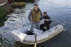 Residents use a boat to move along a flooded street in Egham on February 11, 2014