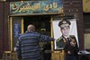 A man sits under a banner with the photo of Defense Minister Gen. Abdel-Fattah el-Sissi as he drinks his tea at the " Al Mosheer Cafe" or "Marshal Cafe" in Cairo, Egypt, Tuesday, Jan. 27, 2014.