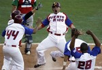 Puerto Rico's Johnny Monell, center, celebrates with teammates at home plate after scoring the game-winning run during a Caribbean Series baseball game against Mexico at Quisqueya stadium in Santo Domingo, Dominican Republic, Monday, Feb. 6, 2012. (AP Photo/Fernando Llano)