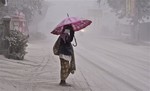 A women walks on a road covered with volcanic ash following an eruption of Mount Kelud, in Yogyakarta, Indonesia, Friday, Feb 14, 2014.