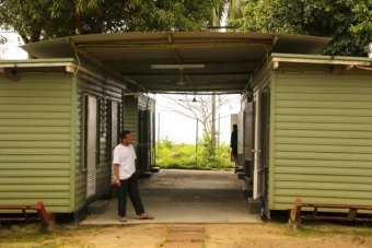 A man stands outside a demountable building on Manus Island