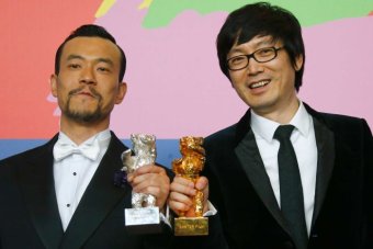 Actor Liao Fan and director Diao Yinan pose with their Berlinale prizes, February 2014