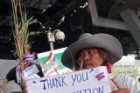 Thai farmers hold bales of rice with protest placards as they demonstrate against the government's repeatedly delayed payments for rice submitted to the pledging scheme at Suvarnabhumi airport in Bangkok February 16, 2014.