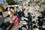 File - Palestinian children stand on the wreckage of their destroyed houses, hit during an Israeli 22 day offensive over Gaza, on July 05, 2009.