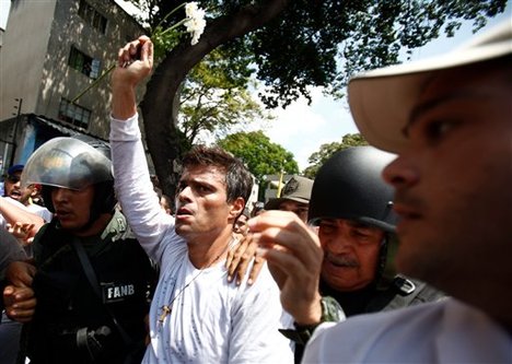 Opposition leader Leopoldo Lopez is flanked by Bolivarian National Guards after Lopez surrendered, in Caracas, Venezuela, Tuesday, Feb 18, 2014.