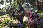 Relatives and friends of Genesis Carmona carry floral arrangements during her funeral, Friday, Feb. 21, 2014 in Valencia, Venezuela. The university student and beauty queen who was slain during a political protest on Feb.18 in Valencia, was buried Friday, a victim of what government opponents say is the kind of indiscriminate violence that has been used to stifle dissent across the country by supporters of President Nicolas Maduro.