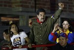 Venezuela's interim President Nicolas Maduro clenches his fist to greet supporters from the top of a vehicle as he campaigns in Caracas, Venezuela, Friday, April 5, 2013.