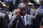 Zimbabwean President Robert Mugabe, attends the burial of Deputy President John Nkomo, at the Heroes Acre, in Harare, Zimbabwe, Monday, Jan, 21, 2013. Nkomo died of cancer aged 79. Mugabe who addressed mourners at the funeral called on Zimbabweans to be united and for peace to prevail in the country ahead of elections set for sometime this year.