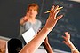 Teacher pointing to raised hands in classroom boarding school

Generic