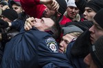 Crimean Tatars clash with a police officer , left, in front of a local government building in Simferopol, Crimea, Ukraine, Wednesday, Feb. 26, 2014.