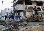 Civilians clear the aftermath of a car bomb attack in the crowded commercial area of Karrada, Baghdad, Iraq, Wednesday, Feb. 26, 2014.