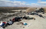 EDS NOTE: GRAPHIC CONTENT - In this photo released by the Syrian official news agency SANA, Syrian government forces stand next to the bodies of rebels south of Damascus, Syria, Wednesday, Feb. 26, 2014.