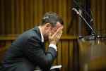 Oscar Pistorius, cradles his head in his hands in court on the fifth day of his trial at the high court in Pretoria, South Africa, Friday, March 7, 2014.