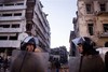 In this file photo taken Tuesday, Dec. 24, 2013, Egyptian policemen stand guard at the scene of a powerful explosion believed to be a car bomb at a police headquarters building that killed at least a dozen people, wounded more than 100, and left scores buried under the rubble, in the Nile Delta city of Mansoura, 110 kilometers (70 miles) north of Cairo, Egypt.