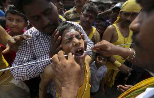 A young devotee of the Tamil community has his mouth pierced with a steel rod in a religious procession during the Muthu Mariamman Puja festival in Mumbai,  March 8, 2014. (EPA/DIVYAKANT SOLANKI)