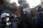 Anti-government protesters shout "Glory to the Ukraine" as they man a barricade at Independence Square in Kiev, Ukraine, Friday, Feb. 21, 2014.