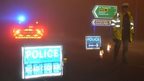 Police officer at a roadblock near the helicopter crash scene