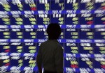 A passer-by looks at an electronic stock board in downtown Tokyo Friday, Oct. 31, 2008. Japan's benchmark stock index closed down 5 percent Friday with investors dumping stocks after the central bank's smaller-than-expected cut in its key interest rate. The Nikkei 225 index lost 452.78 points to close at 8,576.98 point