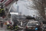 Firefighters continue to investigate and remove debris from an explosion in Harlem, Wednesday, March 12, 2014 in New York.